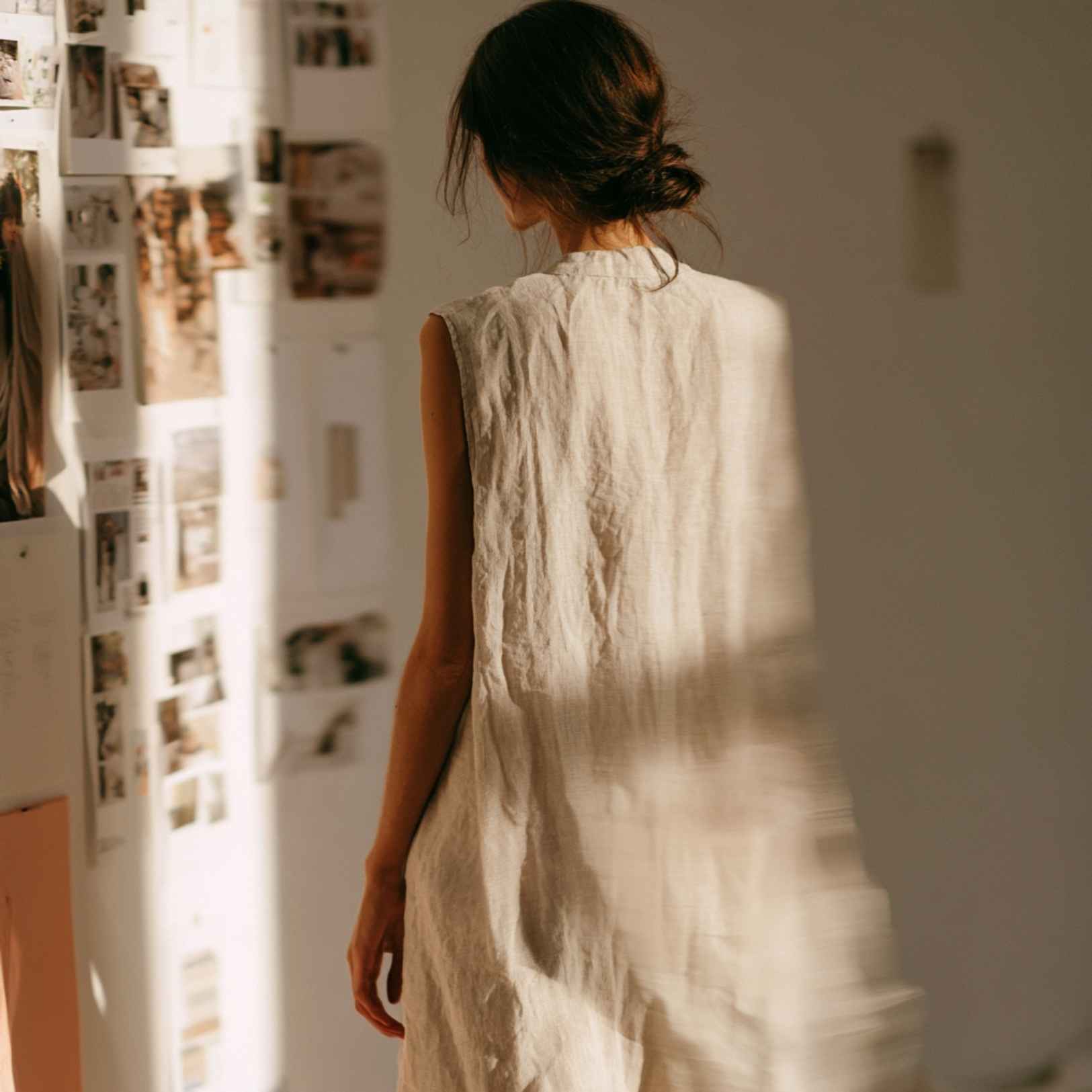 Femme en robe de lin devant un mur d'inspiration, incarnant l'identité de marque beauté bien-être.
