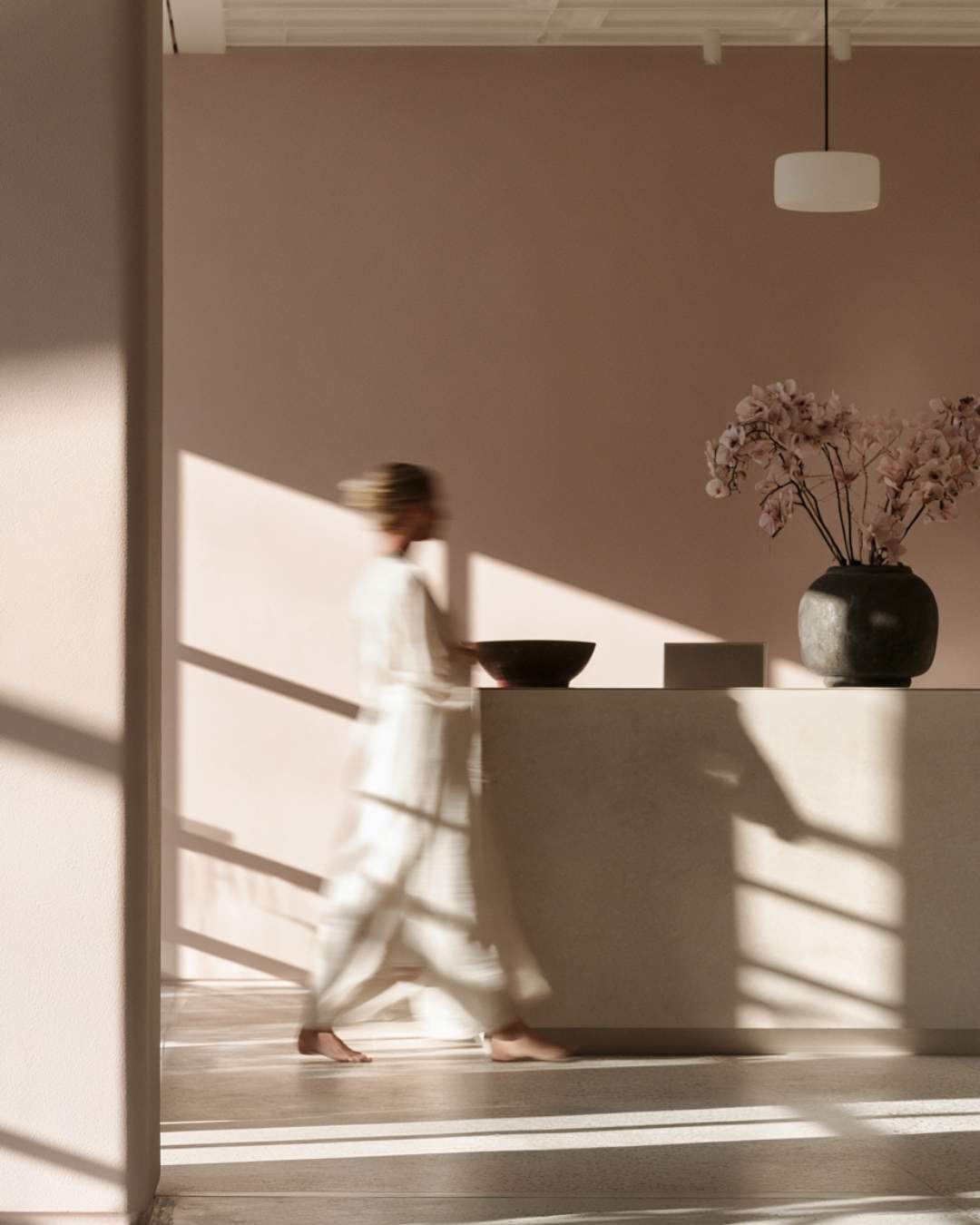 Identité visuelle cohérente d'un accueil spa au positionnement premium, tons rosés et lumière naturelle